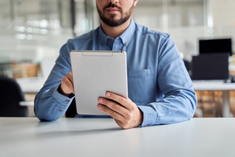 Busy young business man manager using tablet computer, close up.