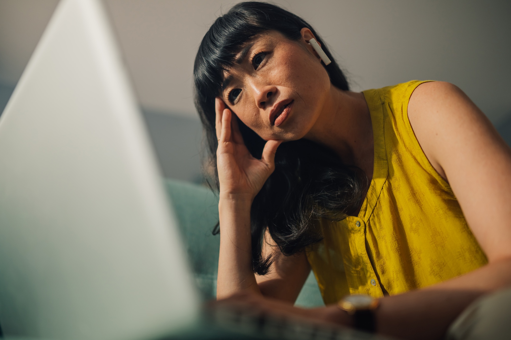 Focused asian woman working on her laptop while solving a problem